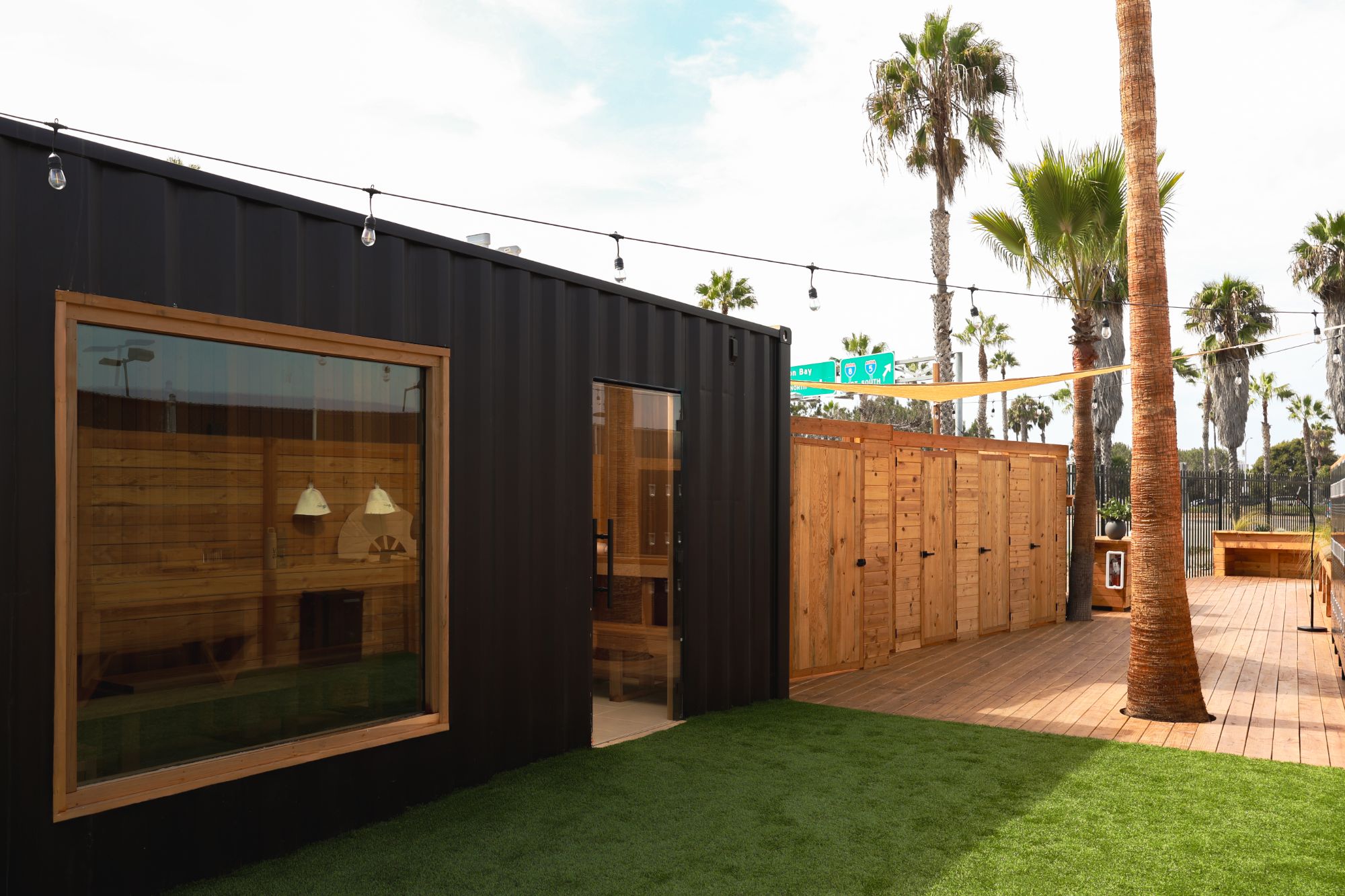 Black sauna container with a large cedar-framed window